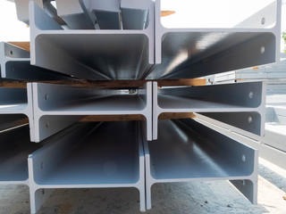 Stacked metal i-beams parts of a pre-fabricated building. Fast-built camp construction parts at the...