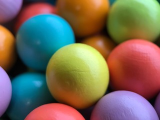 Bright multi-colored background from small wooden colored balls from the developmental toys.Application in the design of catalogs of stores for children, packaging of goods,printing.Top view.Fine moto