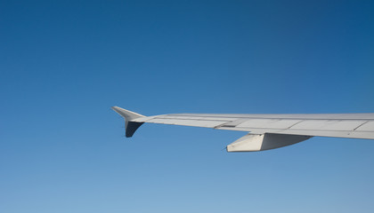 Wing of airplane over white clouds