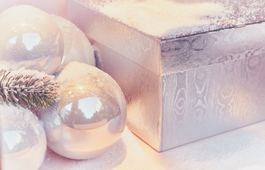 White balls lie on gifts under the christnas tree