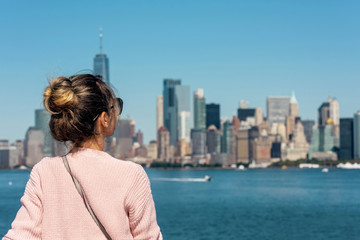 Fototapeta na wymiar Woman in pink sweater posing on the background of New York city