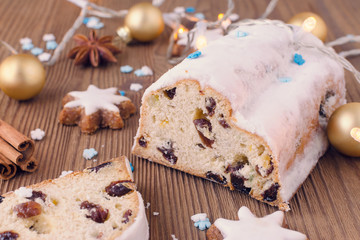traditional german christmas cake stollen with cookies and decoration on wooden table