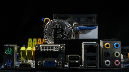 Fototapeta premium Shiny silver bitcoin virtual crypto currency coin laying on electronic circuit motherboard computer
