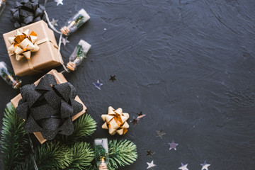 Christmas presents on a black background. Christmas background with fir tree, garlands, gifts.