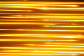 Obraz premium Dark shiny abstract background made of stripes in yellow and brown colors.