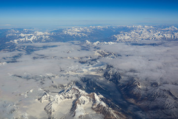 Fototapeta premium Aerial view above snow mountain peaks
