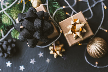 Christmas presents on a black background. Christmas background with fir tree, garlands, gifts.