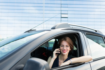 Beautiful girl in strict style of clothing gets out of the car for an important meeting in the...