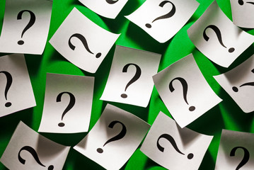 Randomly scattered question marks on white paper