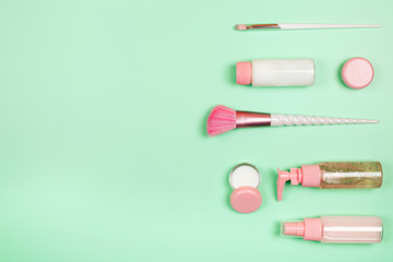 Care cosmetics in bottles on a delicate green background.