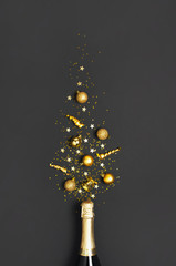 Christmas and New Year background. Champagne bottle, golden christmas balls, festive ribbons, star confetti on black background top view. Flat lay holiday card. Party concept Festive decorations 2020