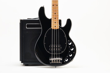 Vintage black electric bass guitar and amplifier on white background