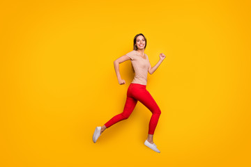 Fototapeta na wymiar Full body profile photo of funky lady jumping high rushing discount shopping store addicted person wear casual striped t-shirt red trousers isolated yellow color background