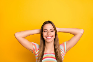 Photo of pretty positive lady resting first summer weekend lying beach eyes closed dreamy mood hands behind head wear casual striped t-shirt isolated yellow color background