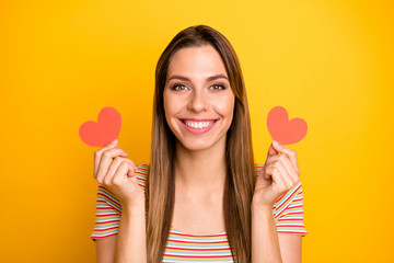 I like it. Closeup photo of funny lady holding hands little red paper hearts flirty girlish mood expressing agreement wear casual striped t-shirt isolated yellow color background