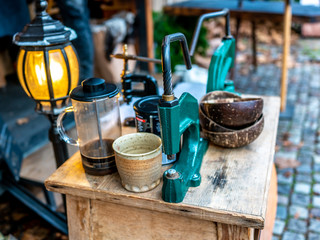 Selective focus on manual coffee bean grinder and utensils on a wooden cabinet on display at the 2019 Christmas market in Maastricht, Netherlands