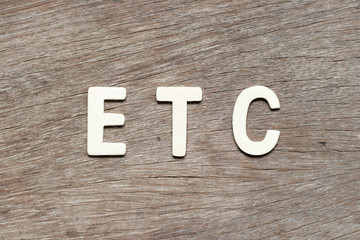 Alphabet letter in word etc (abbreviation of et cetera) on wood background