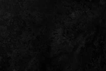 Black low contrast concrete textured wall background with roughness and irregularities to your concept or product.