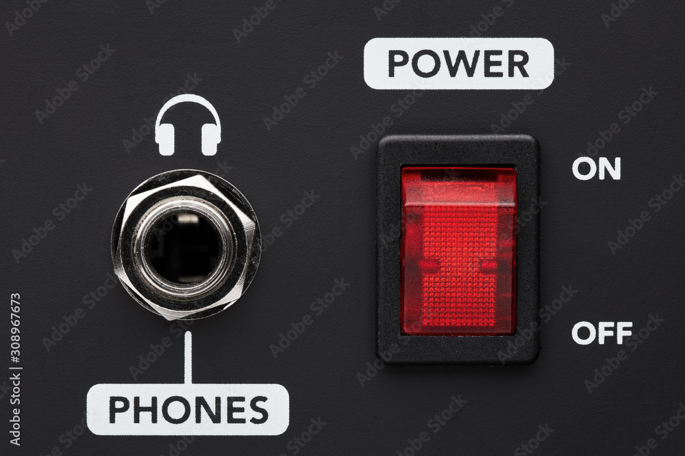 Poster power on and off electrical switch button and headphone input jack on a black amplifier