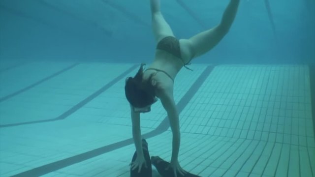 Underwater model mermaid costume in swimming pool. Young woman freediver swims in undine water nymph costume with monofiin.
