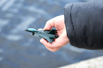 A small toy military plane in the hand of a little boy.