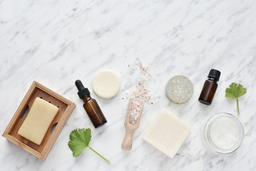 Zero waste cosmetic, natural self care products, soaps, shampoo bars, essential oils, flat lay with copy space on marble background.