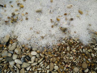 Beach gravel sea foam water