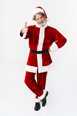 Full length image of Santa Claus man in red costume showing thumb up