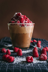 Chocolate mousse pot, two different chocolate with raspberry , against a dark brown background