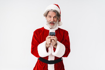 Image of gray-haired Santa Claus man in red costume holding cellphone