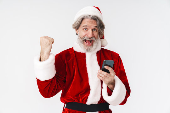 Image of gray-haired Santa Claus man in red costume holding cellphone