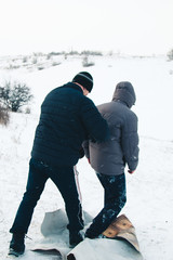 Two friends have fun and enjoy the fresh snow on a beautiful winter day. Snowfall falling in the snow.