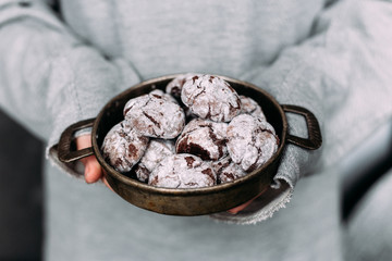 Chocolate Crinkle Cookies in an old plate in a girl's hands