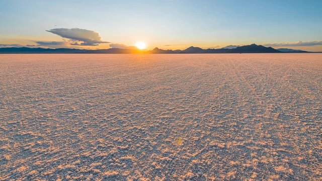 Bonneville Salt Flats blue orange colorful landscape sunset near Salt Lake City, Utah and silhouette view of mountain, sun setting behind clouds
