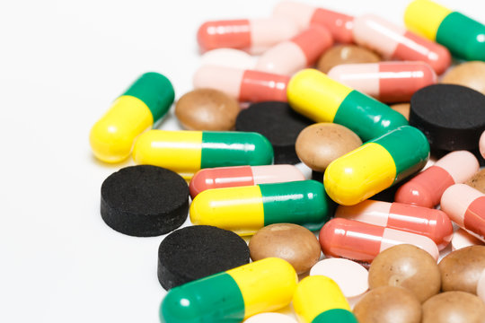 Various pills and capsules on white background closeup view