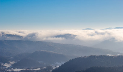 Fog in Beskid Sadecki Mountains in winter. View from Jaworzyna Krynicka, Poland.