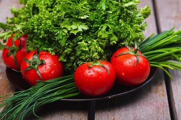 Fresh bright vegetables and herbs on a wooden table.