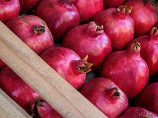 Red ripe pomegranate fruit lie in a box