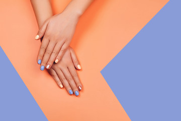 Manicure in trendy colors: coral, rose gold and blue on colorful background. Flat lay style.