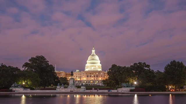Timelapse of the United States Capitol building in Washington DC at night from across the Tidal Basin at night all lit up. Reflection of building in the water in the shot.