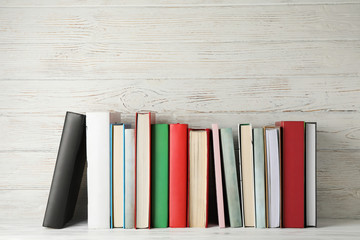 Books against rustic wooden background, space for text