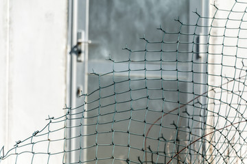 broken metal grill and open in front of the door of a burgled building