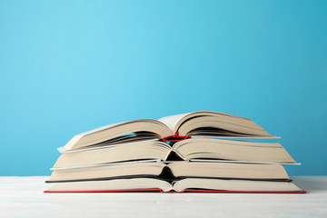 Stack of books against blue background, space for text