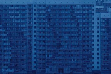 Farbe des Jahres 2020 klassisches Blau. Fassade von mehrstöckigen Hochhäusern mit Loggien und Fenstern. Schöner bunter städtischer Hintergrund. Modisches Pantone-Farbtrendkonzept © Tatyana_Andreyeva