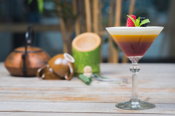 Tiramisu traditional dessert in a glass goblet on a wooden table.