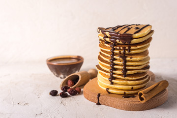  Fresh sweet pancakes with chocolate jam, cinnamon sticks and marshmallows on a gray background with place for your text.