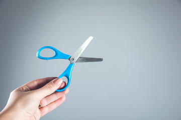 woman hand holding blue scissors
