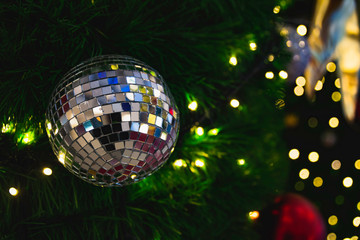 Christmas tree with Decorative lights and mirror ball on blurred background.