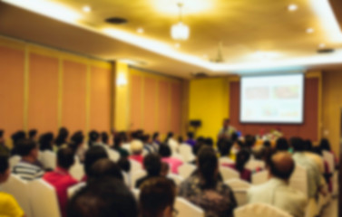 People in meeting or conference room blurred for background.