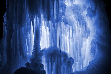 Huge ice icicles. Large blocks of ice frozen water. Blue ice background. Frozen stream waterfall....